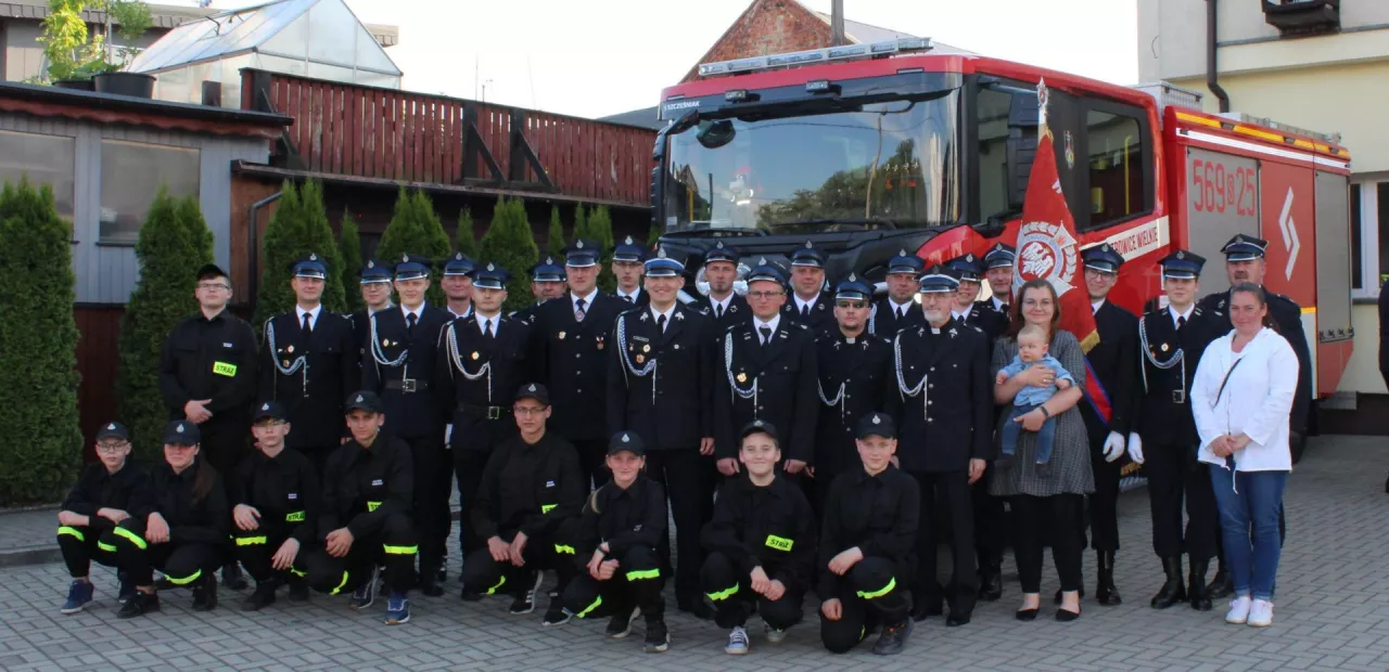 Strażacy OSP Pietrowice Wielkie na tle wozu bojowego, którym m.in. dysponują