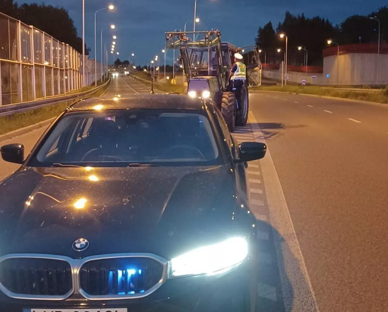 Policjant kontroluje ciągnik rolniczy, który zmierzał w kierunku drogi szybkiego ruchu