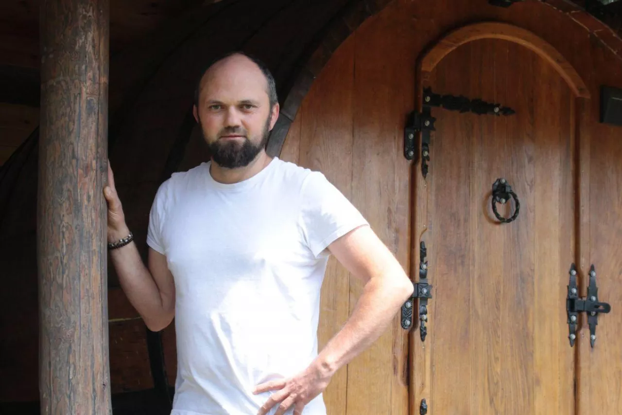 Maciej Piechota przy beczkach-apartamentach. Jeszcze kilka lat temu przechowywano w nich wino. Dziś w takiej mogą się wyspać dwie osoby