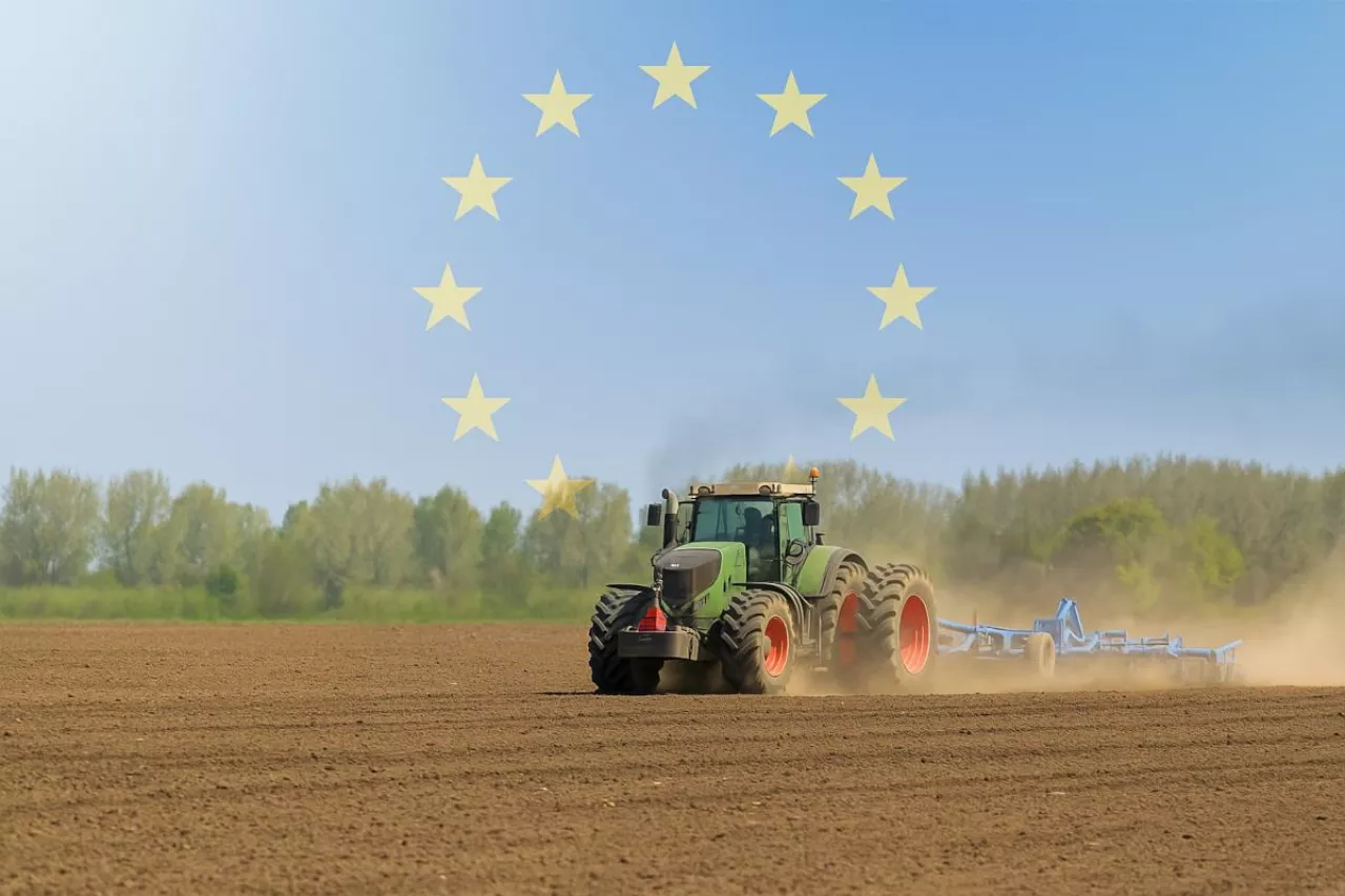Ciagnik rolniczy z kultywatorem z symbolami UE